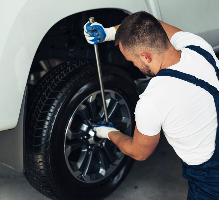 man using lug wrench for tire removal